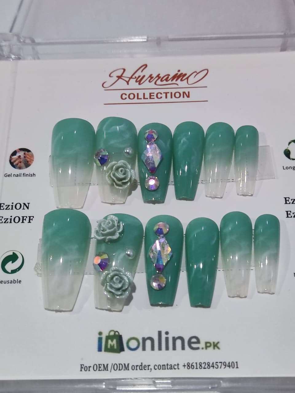 Set of teal nail extensions with decorative elements on a Hurrain Collection branded display box.